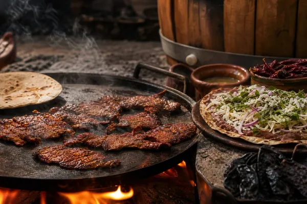 Tasajo oaxaqueño asado a la parrilla con marinada reposada en barril junto a tlayuda y aguacate