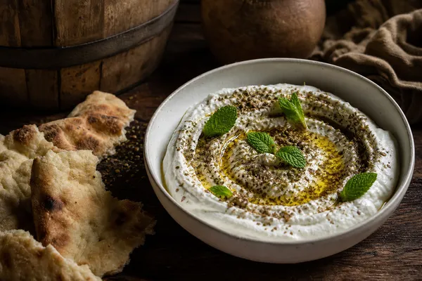 Jocoque cremoso con aceite de oliva, za'atar, hojas de menta y barril de roble